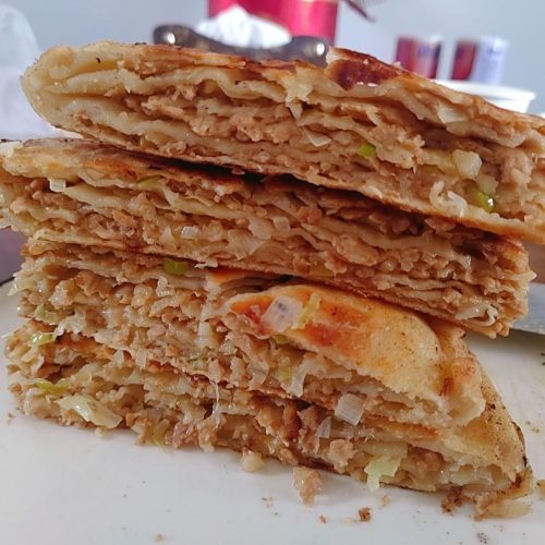 Golden pan-fried zhuang mo bread stacked in tall wedges