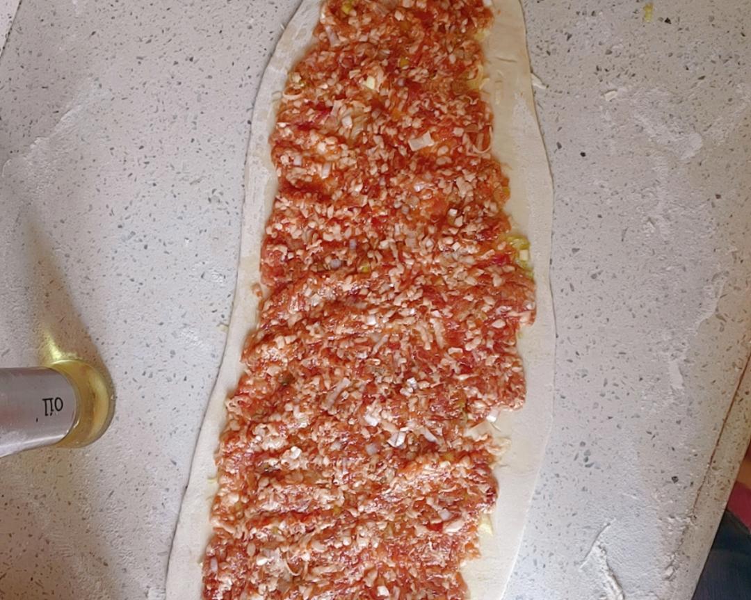 Roll the dough into a thin sheet and brush it with oil, leaving the edges bare
