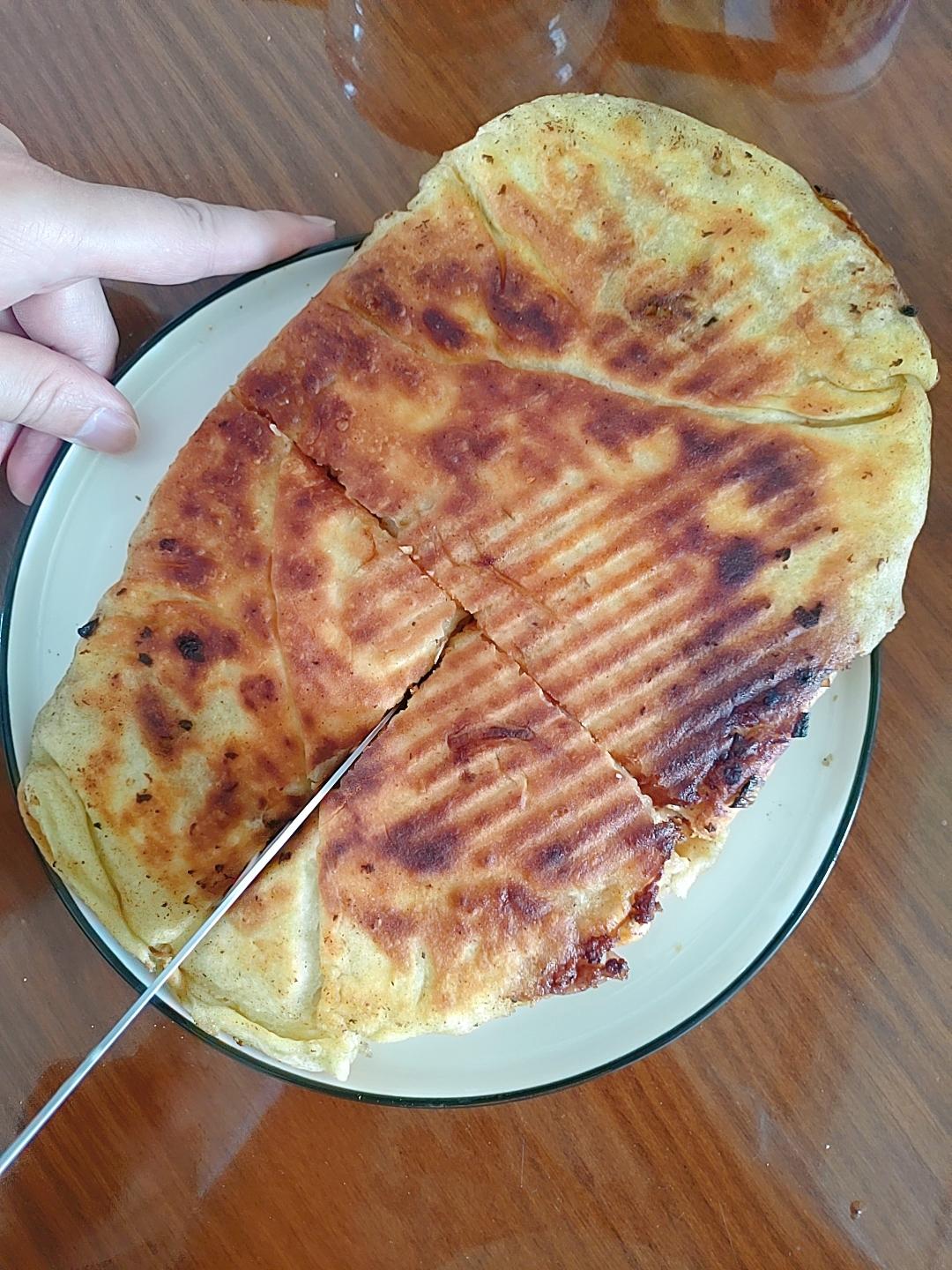 Press the zhuang mo flat in the griddle and fry until both sides are crisp