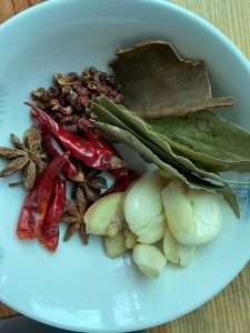 Set out the star anise, peppercorns, chilies, cassia bark, bay leaves, and garlic
