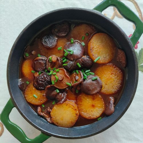 Vegetarian braised daikon radish with dried shiitake mushrooms in soy sauce, glossy and tender