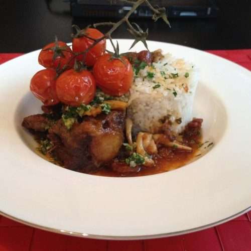 Braised oxtail in red wine with chorizo, carrots and tomatoes, finished with parsley garlic oil