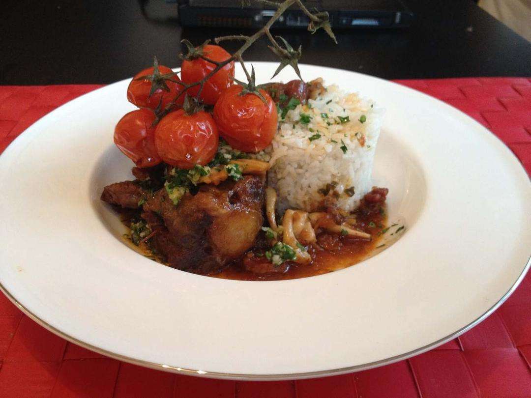Braised oxtail in red wine with chorizo, carrots and tomatoes, finished with parsley garlic oil