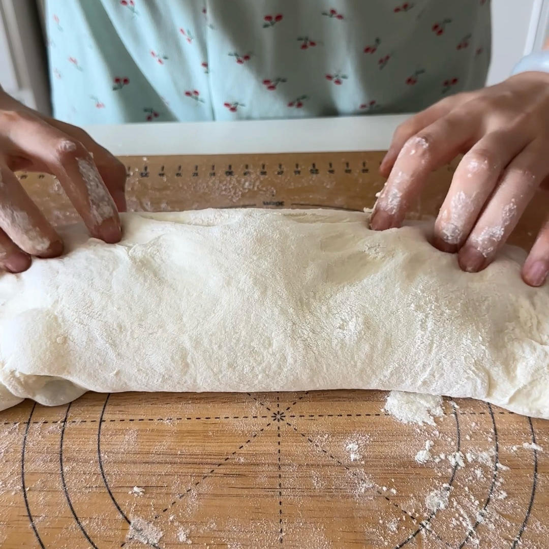 Fold the top edge down to overlap, completing the envelope fold into a long, soft log.