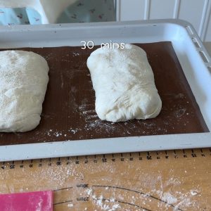 Place the loaves on a floured tray, cover, and proof for 30 minutes while the oven preheats to 230 degrees C.