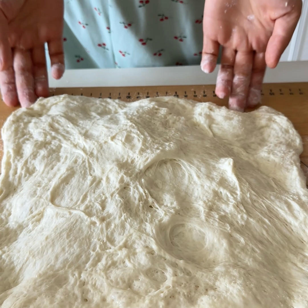 With floured hands, gently coax the dough into a rectangle without pressing out the air.