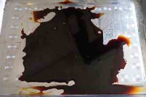 Pour dark soy sauce into a shallow tray for coating the hot pork belly.