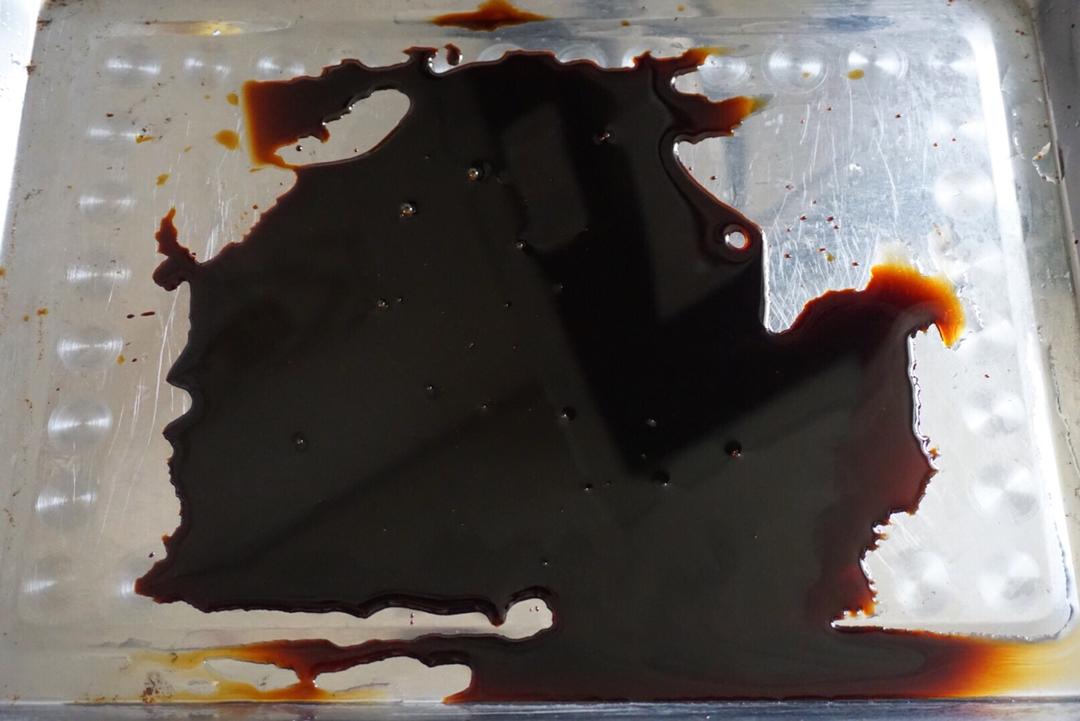 Pour dark soy sauce into a shallow tray for coating the hot pork belly.