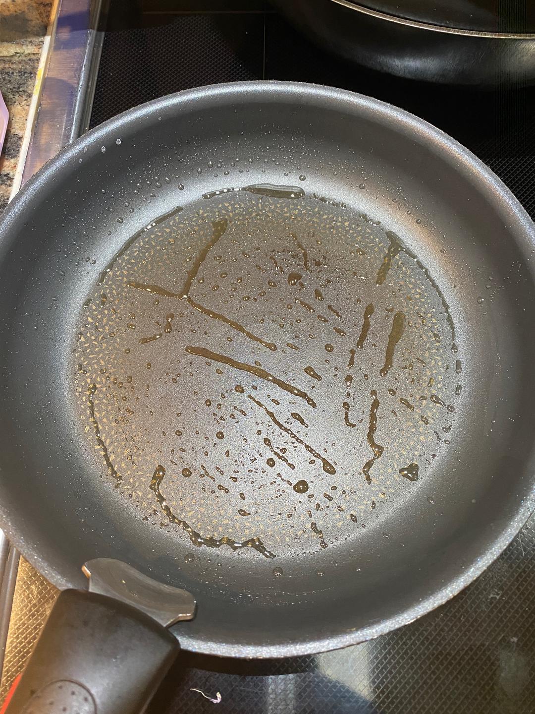 Set the pan over medium-low heat — really, medium-low — and add a thin film of oil, tilting to coat the bottom.