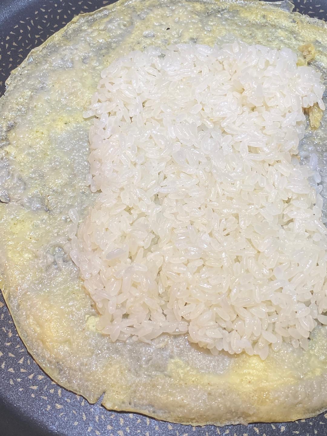 Pile the steamed sticky rice over the crepe and spread it out — edge to edge if you like, or leave a border for easier folding.