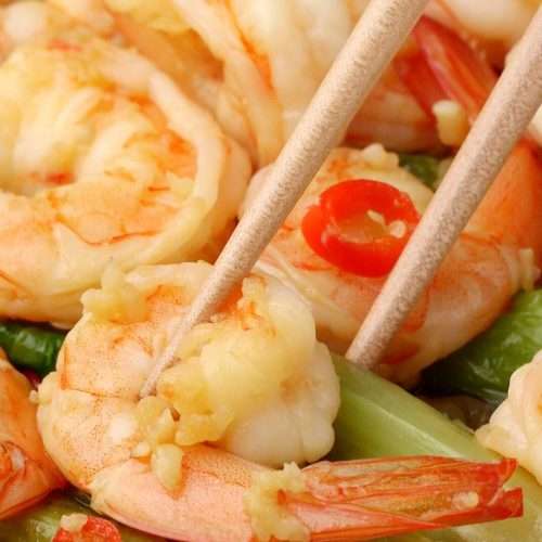 Garlic shrimp and sauce spooned over a bed of blanched green lettuce