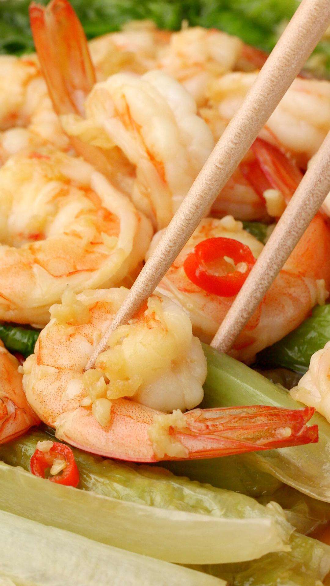Garlic shrimp and sauce spooned over a bed of blanched green lettuce
