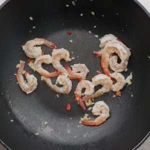 Sizzle the garlic and chili on low heat, then cook the shrimp until pink