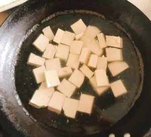 Blanch the tofu pieces in boiling water