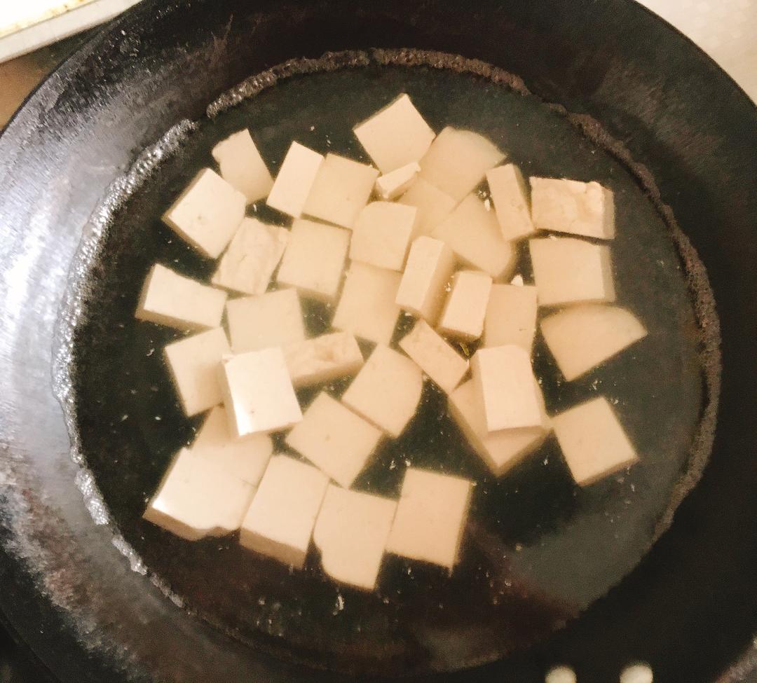 Cut the tofu into pieces and blanch to remove