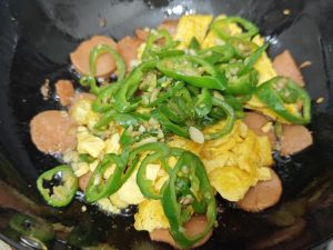 Return the egg and peppers to the wok with the ham