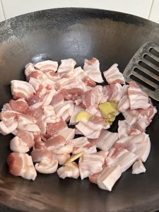 Lay the pork belly slices in a single layer in a cold wok, then turn the heat to high.