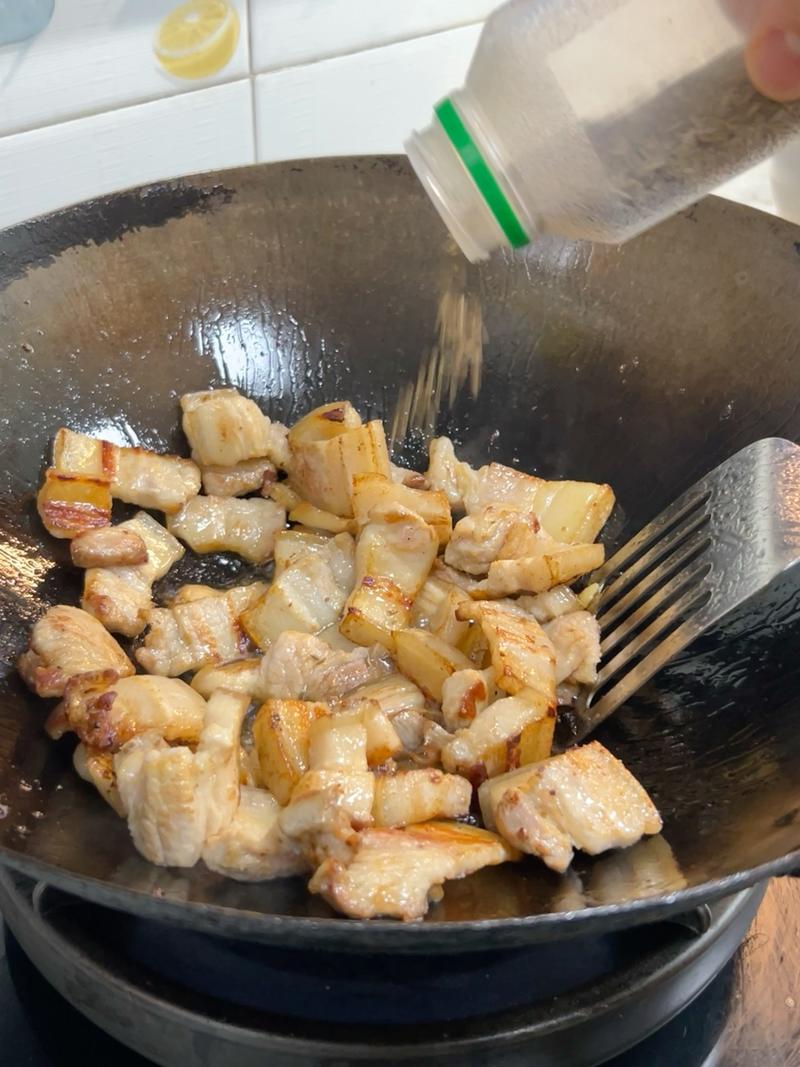 Add a handful of cumin seeds and fry them in the rendered pork fat until fragrant.