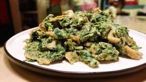Serve the scramble immediately, with the eggs soft and the greens bright green.