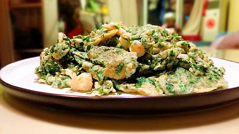 Shepherd's purse and shrimp scrambled eggs, soft yellow with bright green greens and pink shrimp