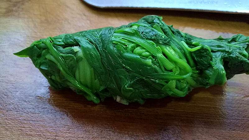 Squeeze every drop of water out of the blanched greens.