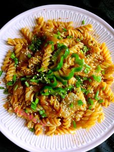 Garnish the kimchi pasta with scallion and sesame