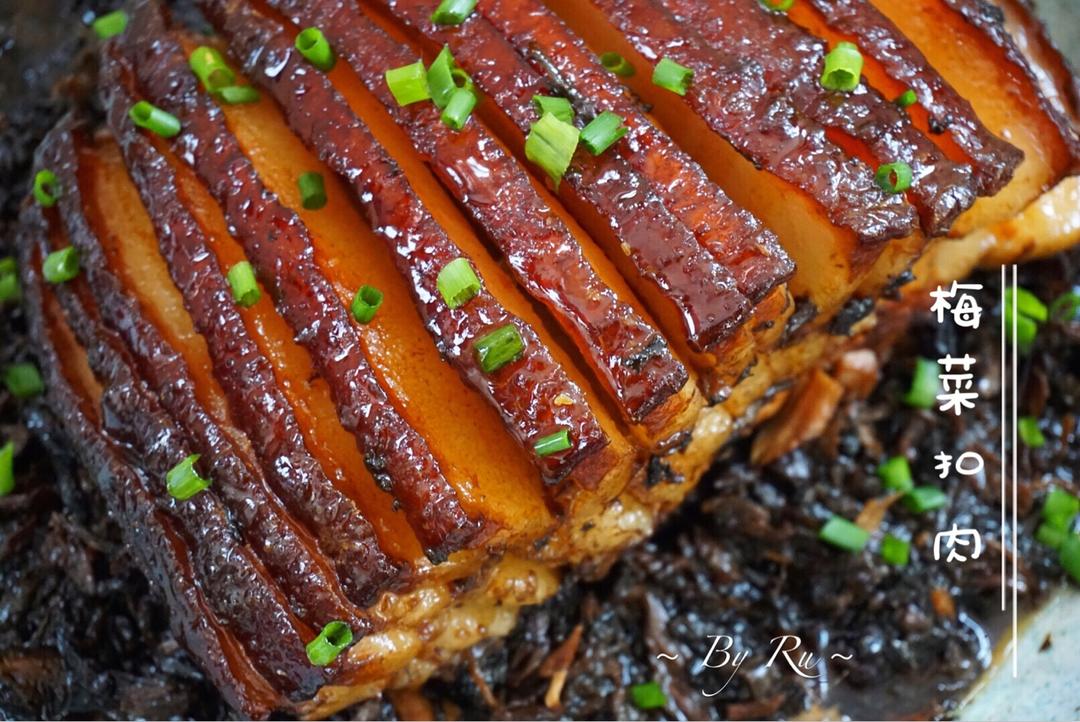 A slice of finished kou rou showing blistered skin, tender pork and sauce-soaked preserved greens.