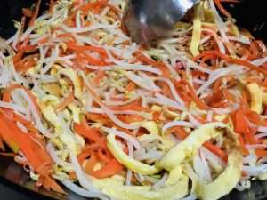 Toss the sprouts, vermicelli, and egg ribbons with light soy sauce