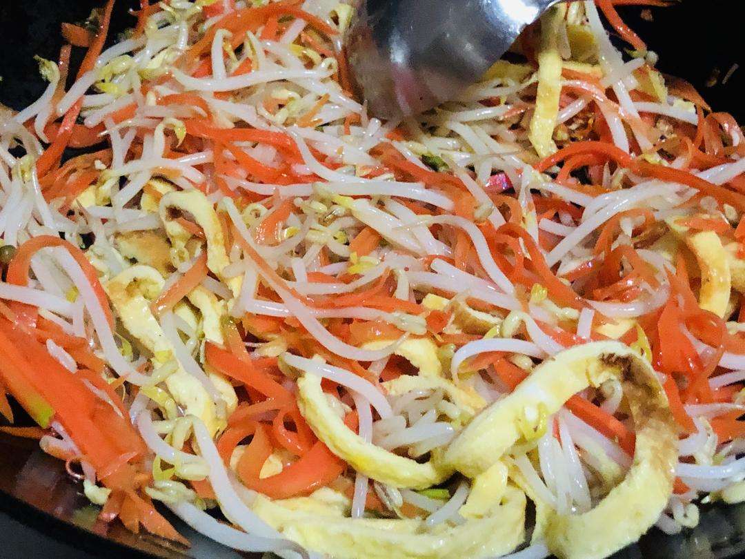 Toss the sprouts, vermicelli, and egg ribbons with light soy sauce