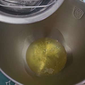 Whip the chilled egg whites on high speed, adding the sugar in three additions: when foamy, when white and flowing, and when soft peaks begin to form.