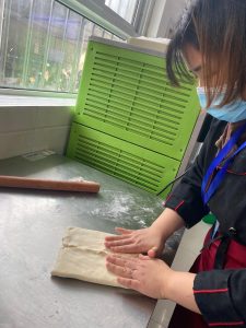 Roll the rested dough into a rectangle about 20 x 32 cm (8 x 12.5 in). Place the butter block in the center, then fold the left and right sides of the dough over the butter like a letter, meeting in the middle. Pinch the seam shut firmly so no butter escapes during the next rolls.