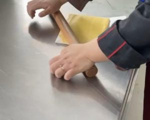While the dough rests, place the softened laminating butter between two sheets of plastic wrap or parchment and roll it into a rectangle about 18 x 15 cm (7 x 6 in). Keep the thickness even.