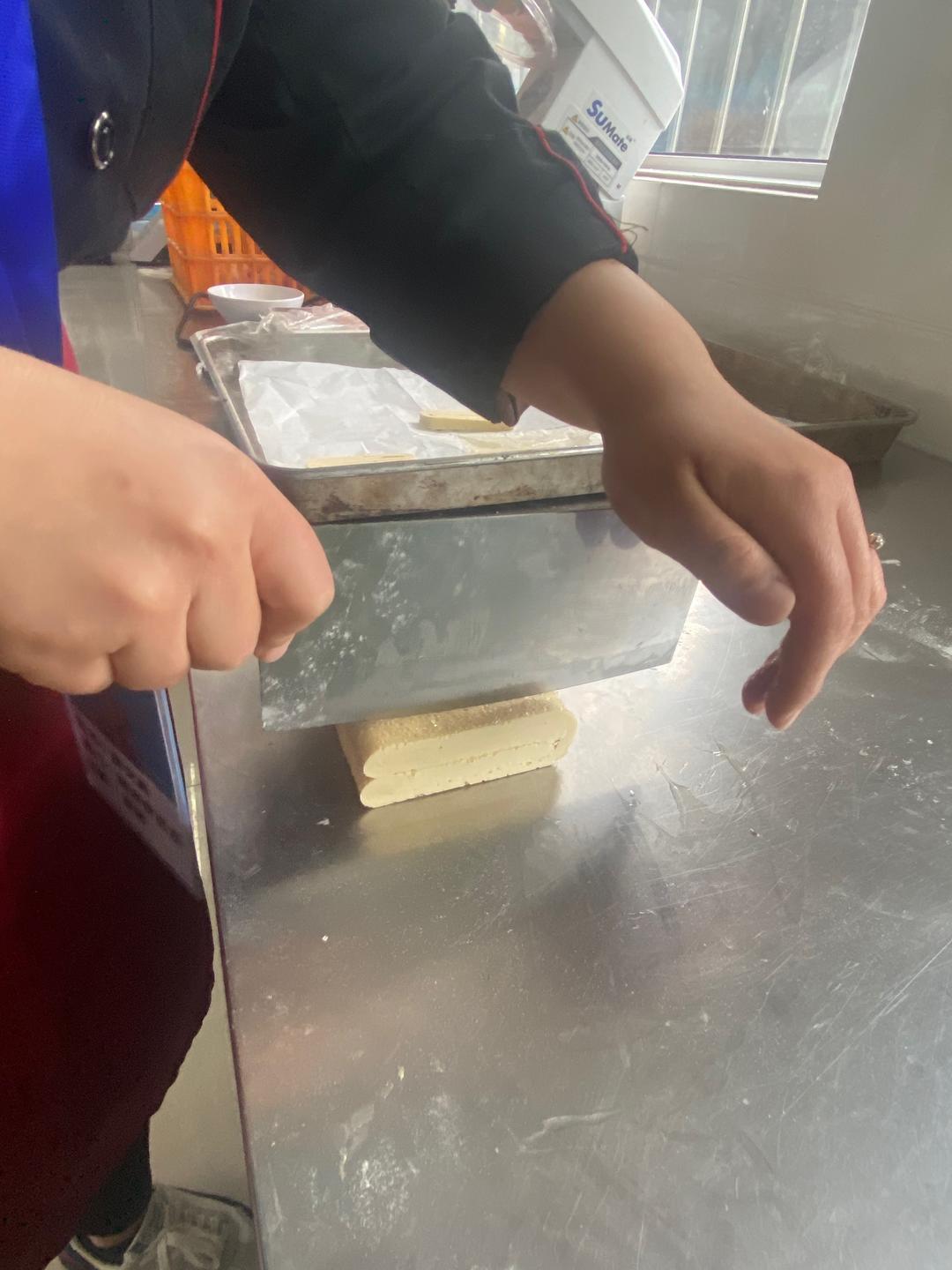Using a sharp knife, cut the frozen block into 1 cm (about 1/2 in) strips. Arrange them cut-side up on a parchment-lined baking tray, leaving a few centimeters between them — they spread and puff as they bake.