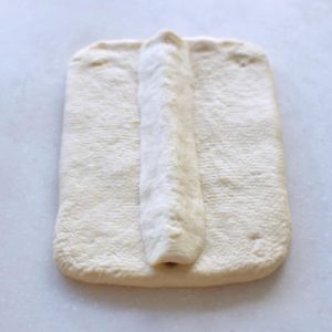 Roll the 35 g white piece into a thin strip, place it above the nose, and press into a triangle with no trapped air.