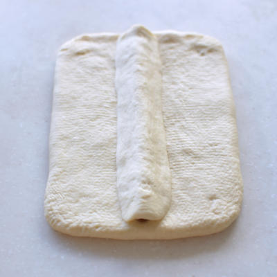 Roll the 35 g white piece into a thin strip, place it above the nose, and press into a triangle with no trapped air.