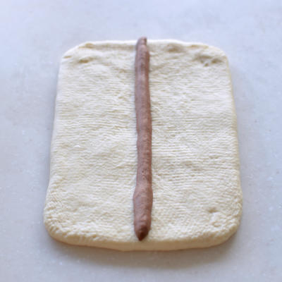 Roll the largest white piece into a rectangle the length of the mold, then lay the 10 g brown strip down the center as the nose.
