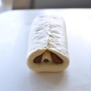 Fold the two sides of the base dough up over the eyes and pinch the seam tightly.