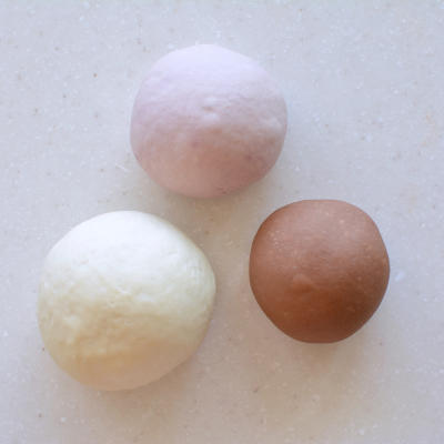 Three colored doughs - white, pink and brown - covered for the first fermentation.