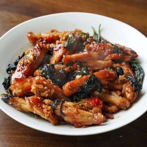 Pan-fried perilla chicken wings glazed and garnished with fresh perilla leaves