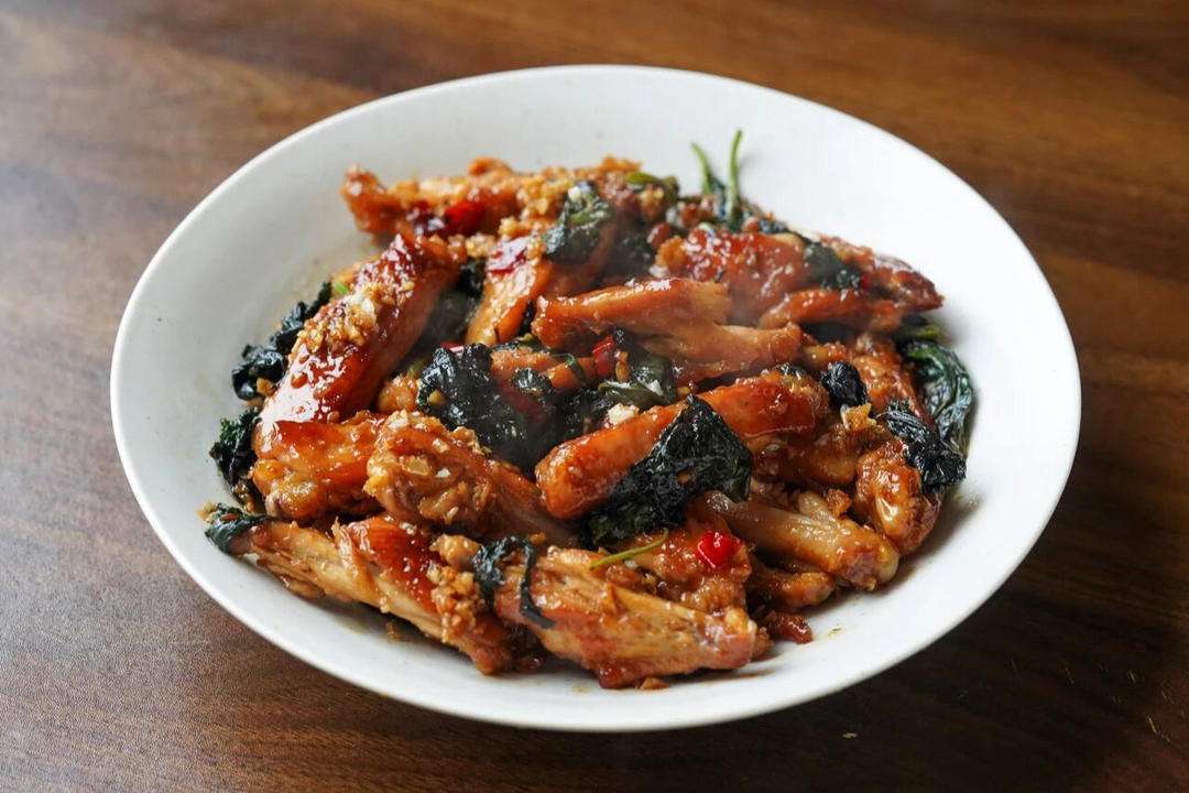 Pan-fried perilla chicken wings glazed and garnished with fresh perilla leaves