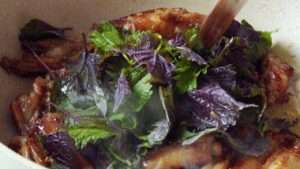 Bloom the minced garlic and bird's eye chili rings in the pan oil before tossing with the wings