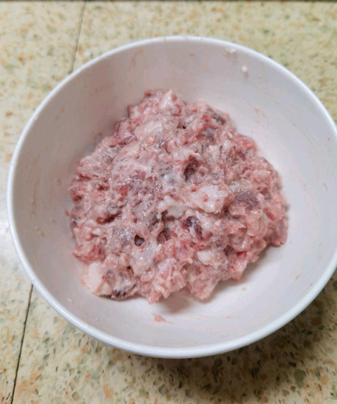 Mix with your hand until every single piece is coated in the starchy slurry, with no dry flour left in the bowl and no bare patches of pink meat.