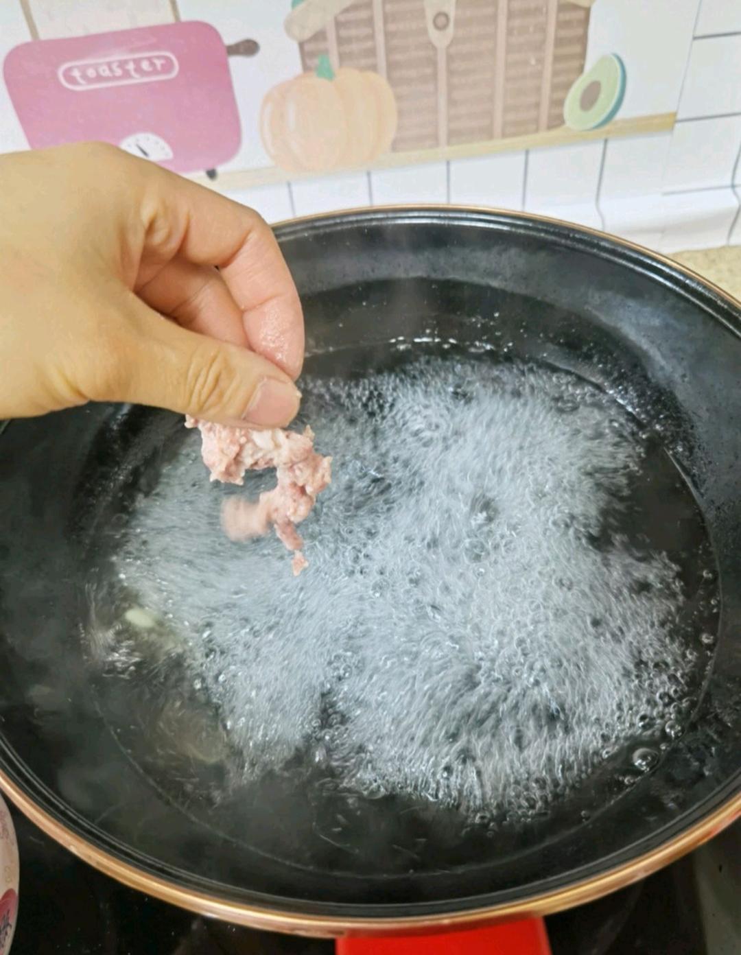 Bring the water to a full rolling boil in the pot, add a little oil, and drop the coated pork pieces in one at a time. Do not stir after adding — the coating needs a moment to set.