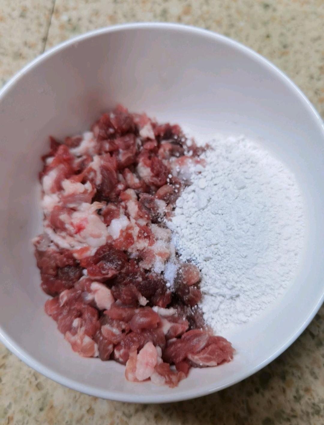Slice the pork, then chop it a few more times until you have coarse, irregular pieces. Season with the black pepper and salt, add a generous amount of sweet potato starch and a little water.