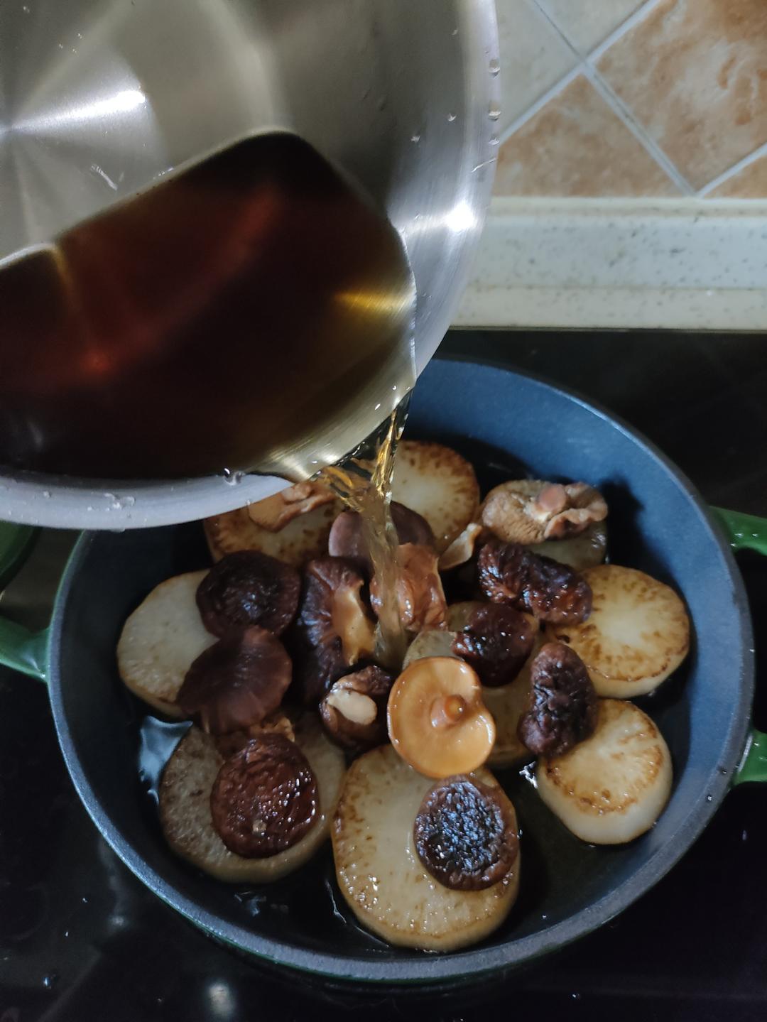 Add the rehydrated shiitake mushrooms and their soaking water to the pan.