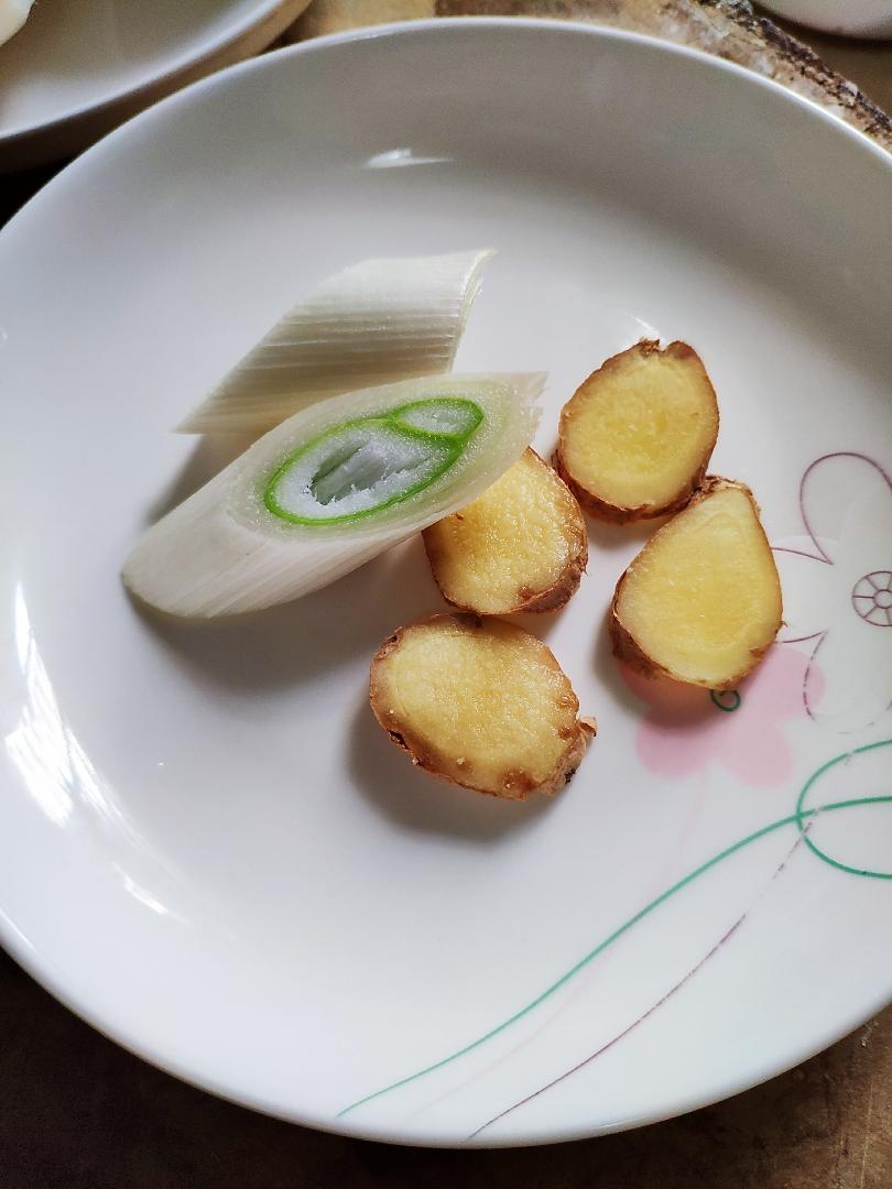 Prepare the aromatics: two scallion sections and four ginger slices.