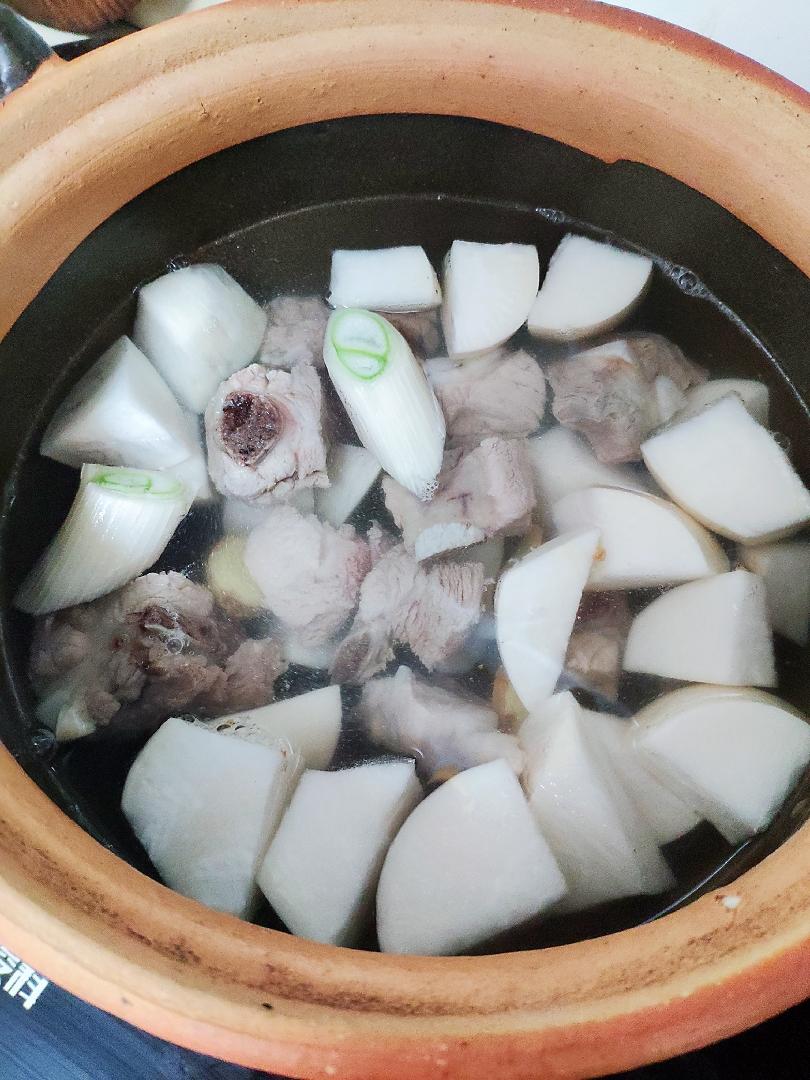 Add the ribs, radish and aromatics to the clay pot, then pour in hot water.
