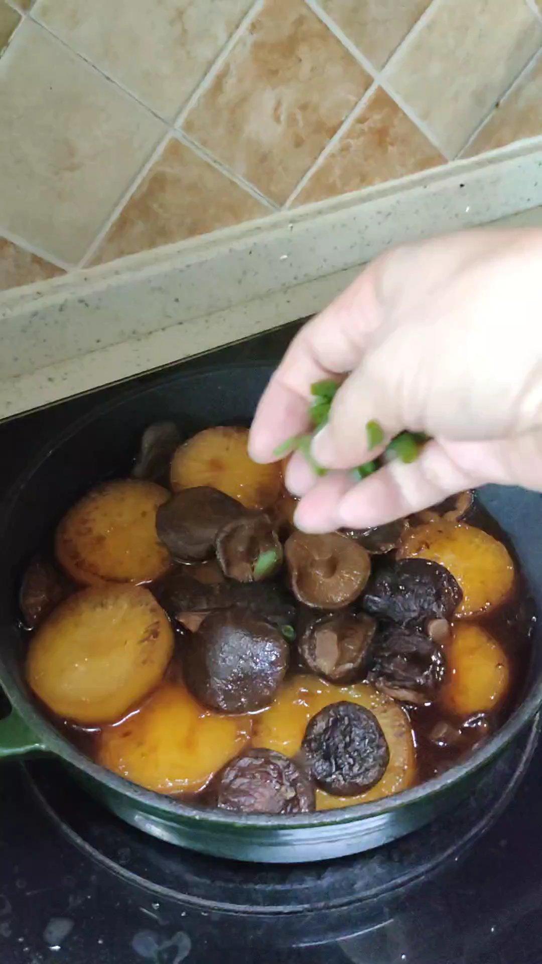 Sprinkle sliced scallions over the braised radish and serve hot.