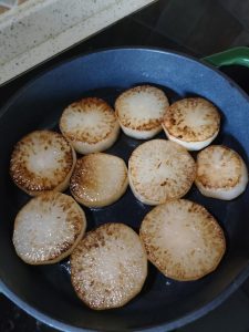 Peel the daikon, cut into thick coins and fry until golden on both sides.