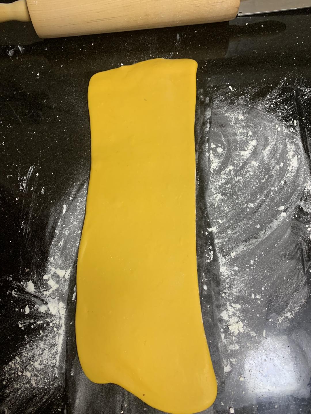 Rolling the dough flat with a rolling pin